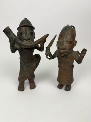 paire de figurines en bronze représentant un homme et une femme tenant des couteaux