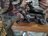 une femme en train de prendre en photo une statue de chien exposée dans une vitrine