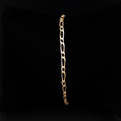 un bracelet en or avec un maillon sur fond noir