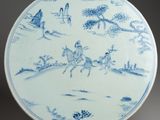 assiette bleue et blanche représentant un homme à cheval et un homme sur un cheval