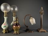 Plusieurs lampes anciennes sont alignées sur un fond gris