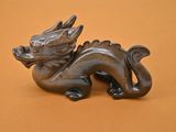 une statue représentant un dragon assis sur une table