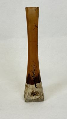 a glass vase with a tree on it on a white surface