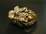 une bague en or et diamants posée sur une surface noire