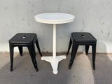 deux tabourets et une table devant un mur