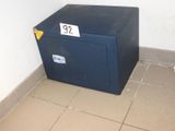 un coffre-fort bleu posé dans un coin d'une pièce