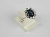 a close up of a ring with a black stone surrounded by white diamonds