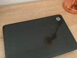 a black mouse pad on a wooden desk next to a lamp