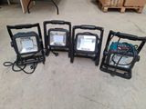 four different types of portable flood lights are lined up on the floor