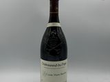 une bouteille de vin rouge avec une étiquette blanche sur fond gris