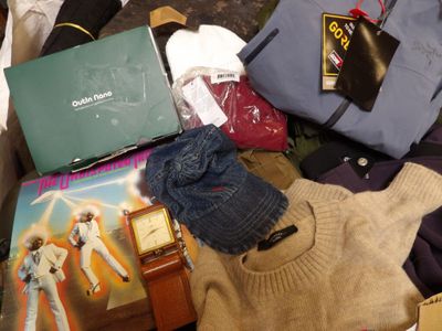 a pile of clothing and a suitcase on the floor