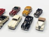 several toy cars are lined up in a row on a white surface