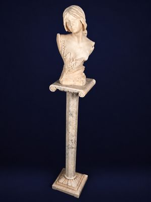 a white marble busturine of a woman on a pedestal
