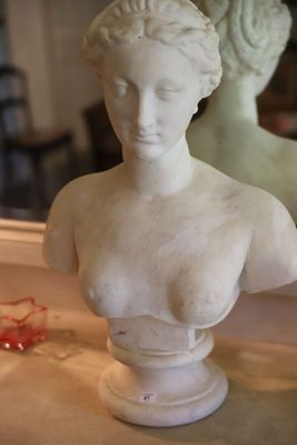 un buste de femme assise sur une table devant un miroir