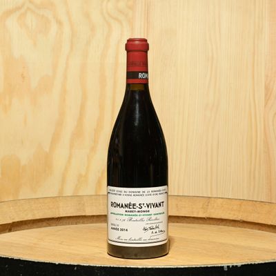 a bottle of wine sitting on top of a barrel
