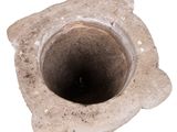 a stone vase with a hole in it on a white surface
