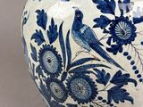 a blue and white vase with a bird on it