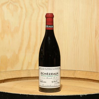 a bottle of wine sitting on top of a barrel