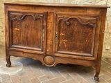 a wooden cabinet that is sitting on a brick floor