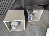two empty bottles of water in a box next to a computer