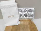 a silver purse sitting on top of a wooden cutting board