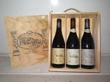 trois bouteilles de vin se trouvent dans une caisse en bois posée sur un comptoir