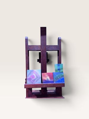 un petit chevalet sur lequel sont posés des tableaux, sur une surface blanche