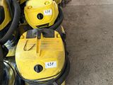 several yellow vacuum cleaners are lined up on the floor