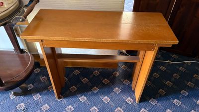 a small wooden table with a chair next to it