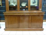 a wooden china cabinet with glass doors in a room