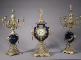 trois vases bleus et dorés, sur chacun desquels se trouve une horloge