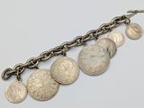 a close up of a chain bracelet with coins on it