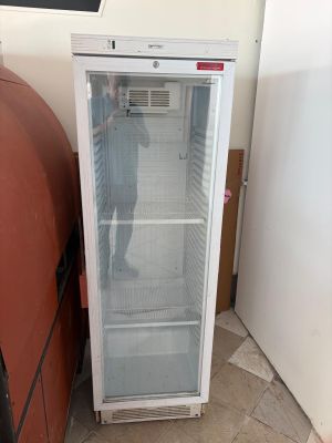 a refrigerator that is sitting next to a trash can