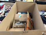 Plusieurs cartons de vêtements sont empilés les uns sur les autres dans une pièce.