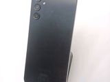 the back of a black cell phone sitting on top of a white surface