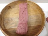 a wooden bowl with a pink tie on top of it