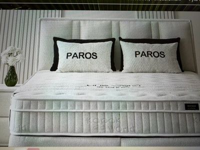 two pillows on the bed that say paros and paros
