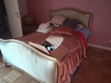 a bed with a wooden head board and a pink wall