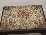 a small wooden stool with a floral pattern on it