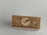 a gold bar with a screw on it on a white surface