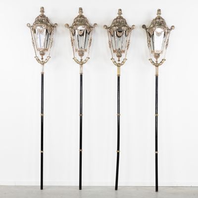 un ensemble de trois lampes en métal argenté et noir accrochées à un mur blanc