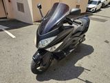 une moto noire garée sur un parking à côté d'un immeuble