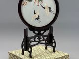 une image représentant une horloge posée sur un socle, sur laquelle est perché un oiseau