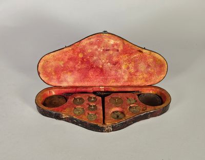 une vieille valise ouverte posée sur une surface blanche