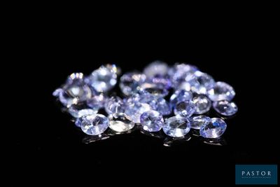 a close up of a bunch of blue sapphires on a black surface