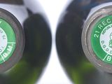 two bottles of wine that have green labels on them