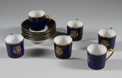 six tasses et une soucoupe ornées d'une bordure dorée, ainsi qu'une assiette sur laquelle est posé un bol