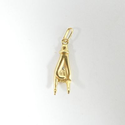Le pendentif en or a la forme d'une main de femme coiffée d'un chapeau