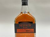 un gros plan d'une bouteille de whisky posée sur une surface blanche