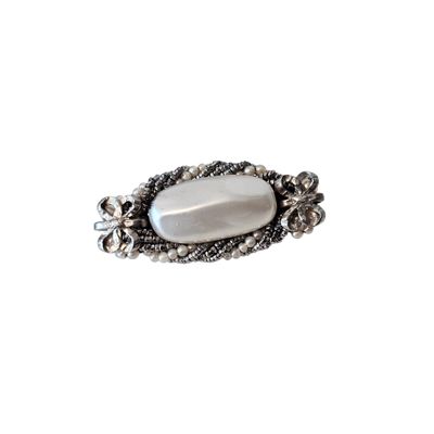 a close up of a ring with a white stone in it